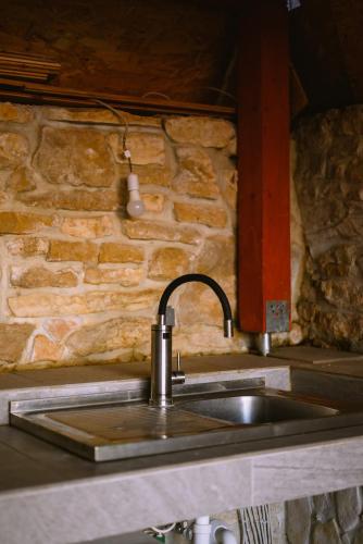 a sink in a kitchen with a stone wall at Stars in Gornji Karin