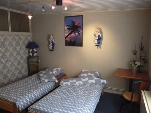a bedroom with two beds and a table and a desk at Désir D'un Soir in Lessines