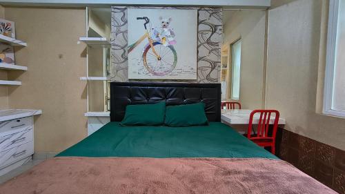 a bedroom with a large bed with green sheets and a red chair at Student Castle Apartement by Dev's Room in Seturan