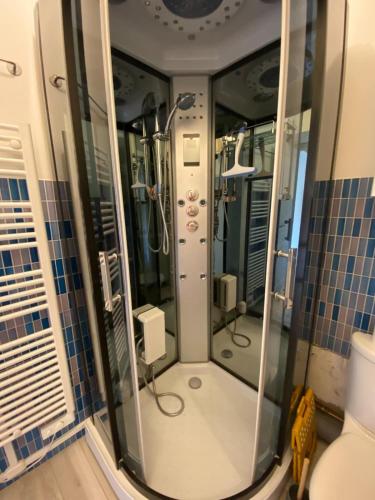 a shower in a bathroom with blue tiles at Le Sunny Hardelot in Neufchâtel-Hardelot