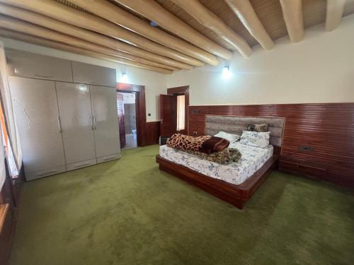 a bedroom with a bed in a room with green carpet at Cho Farm House in Leh
