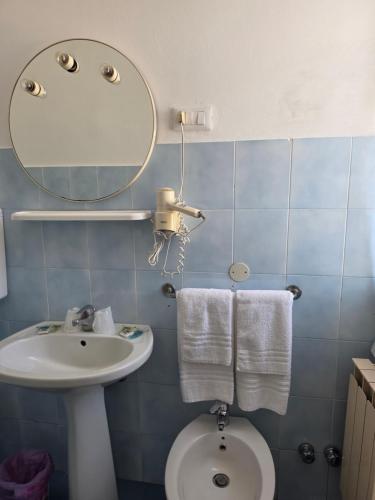 a bathroom with a sink and a toilet and a mirror at Albergo Bandoni in Rapallo