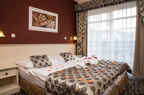 a bedroom with a bed with two stuffed animals on it at Spa hotel Čajkovskij in Karlovy Vary