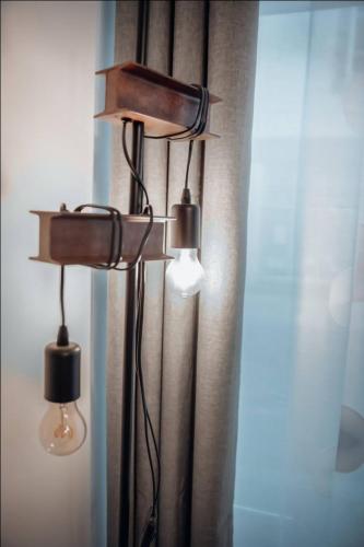 a lamp with two lights next to a window at 1 Le Cocon Mosaïque Centre-ville in Ernée