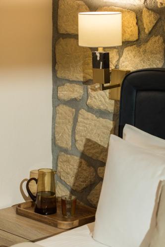a lamp on a table next to a bed at Meteora boutique villa A in Kalabaka