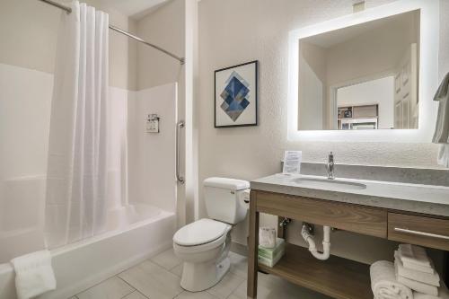 a bathroom with a toilet and a sink and a mirror at Candlewood Suites Longview by IHG in Longview