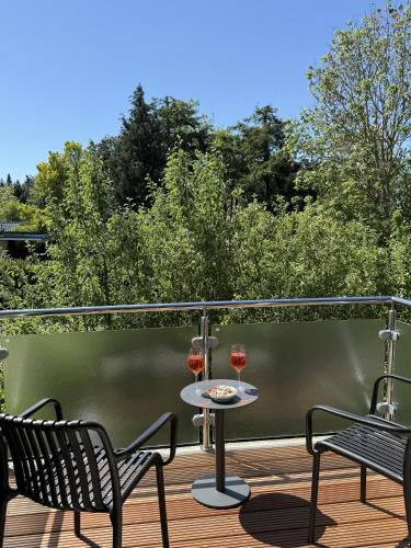 two glasses of wine sitting on a deck at 4Strandzeiten - Ferienhaus Luv in Timmendorfer Strand