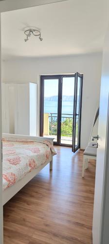 a bedroom with a bed and a view of the ocean at Smit apartman in Novi Vinodolski