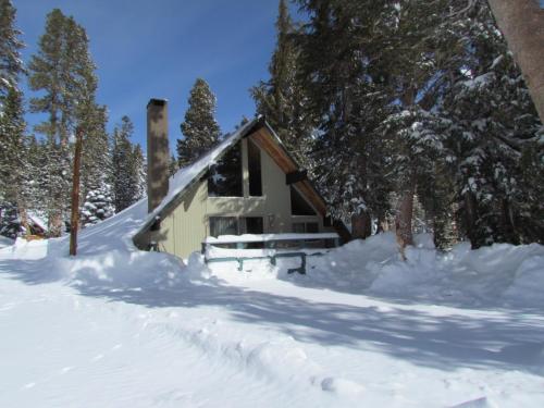 a small cabin in the snow with trees at Chalet 15 by Mammoth Mountain Chalets in Mammoth Lakes