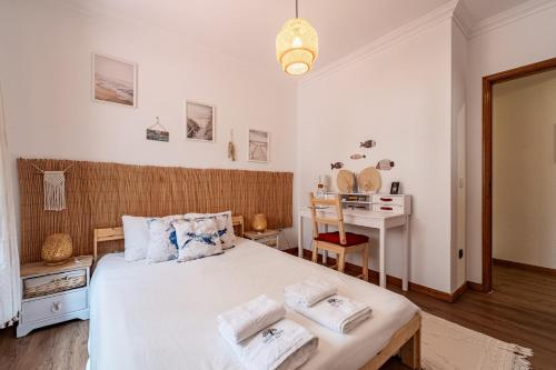 a bedroom with a bed with two towels on it at Guest House Da Mata3 in Póvoa de Varzim