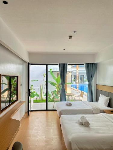 a hotel room with two beds and a large window at Diver's home resort in Panglao Island