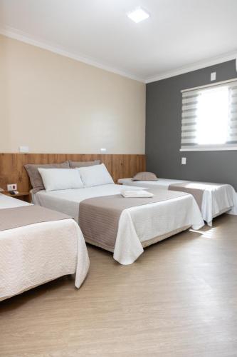 a bedroom with two beds and a window at Hotel Descalvado in Descalvado