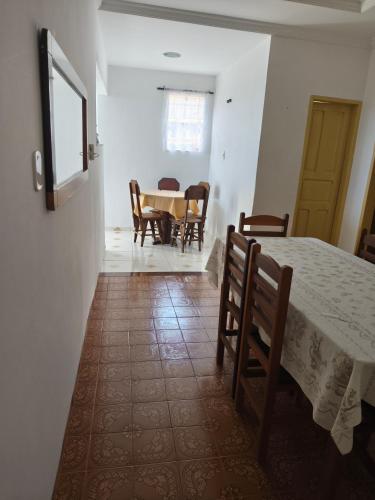a room with a table and chairs and a dining room at Casa ampla in Muriaé