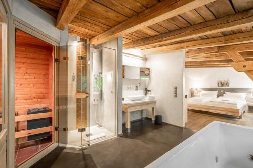 a bathroom with a tub and a sink and a bedroom at Klostermühle in Groß Meckelsen