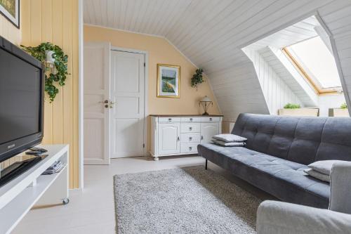 a living room with a couch and a tv at Lyckebo in Gunnebo