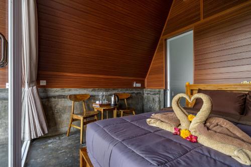a bedroom with a bed with two swans on it at Pandawa Glamping Kintamani in Bangli