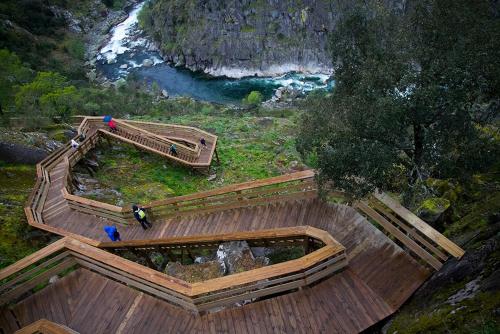 an overhead view of a wooden walkway next to a river at Casa da Azenha- Riverside Retreat by Paiva River Beach in Paradinha