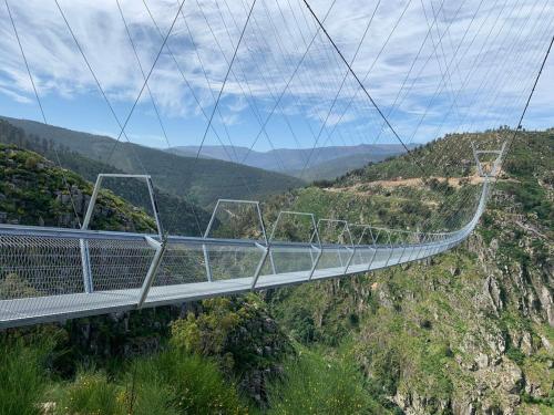 a suspension bridge on a mountain with a view at Casa da Azenha- Riverside Retreat by Paiva River Beach in Paradinha