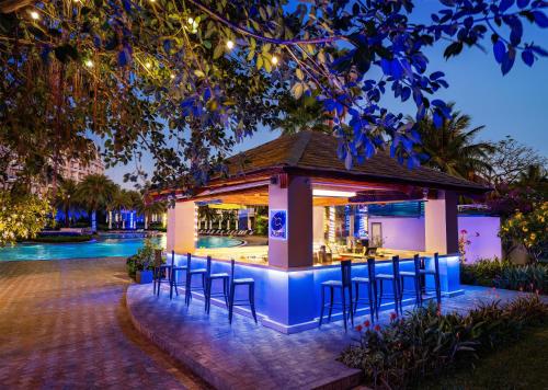 a bar with chairs in front of a pool at night at Radisson Blu Resort Phu Quoc in Phú Quốc