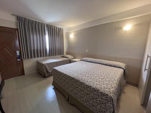 a hotel room with two beds in a room at Atibaia Residence Hotel & Resort in Atibaia