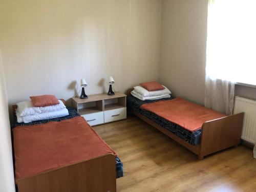 a room with two beds and a table with two lamps at Apartament Zielone Buki in Buczkowice