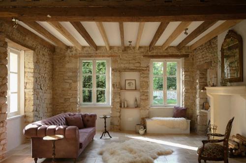 a living room with a couch and some windows at La Petite Noble in Commentry