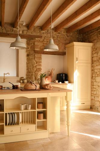 a kitchen with a white island in a room at La Petite Noble in Commentry