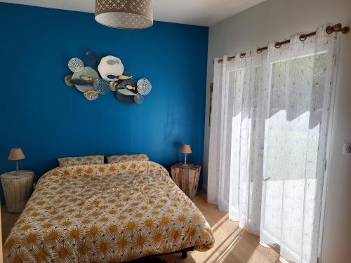 a blue bedroom with a bed and a blue wall at Maison Fabien in Surzur
