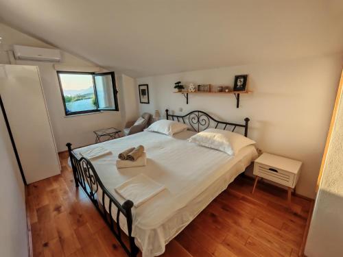a bedroom with a large bed with a wooden floor at Holliday home Alida with jacuzzi in Podgora