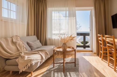 a living room with a couch and a table and a window at Prie Marių Nida in Nida