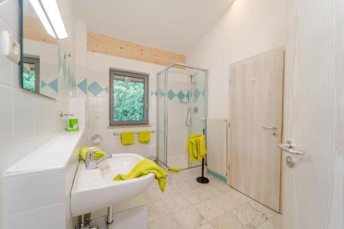a white bathroom with a sink and a shower at Residence Passerhaus in Schenna