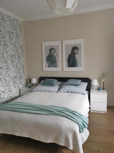 a bedroom with a bed and two pictures on the wall at CASA MINI 5 in Pécs