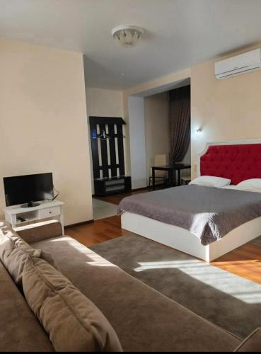 a bedroom with a bed and a tv and a couch at Helen Hotel in Mykolaiv