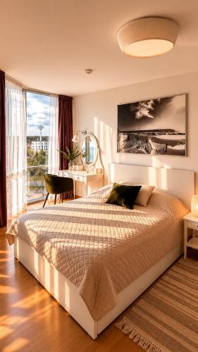 a bedroom with a large bed and a desk at ToVa Apartamentai in Šventoji