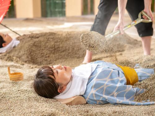 a woman laying on the ground in the sand at Kirishima Kokusai Hotel in Kirishima