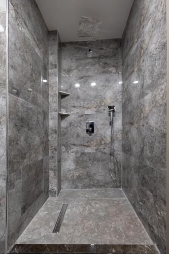 a bathroom with a shower with a stone wall at Asil Luxury Boutique in Burhaniye