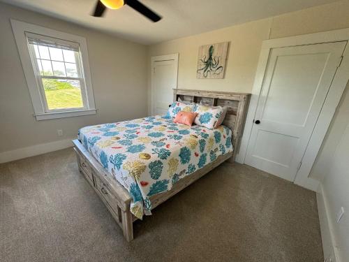 a bedroom with a bed with pillows and a window at Sun2Sand Beach House in Salisbury
