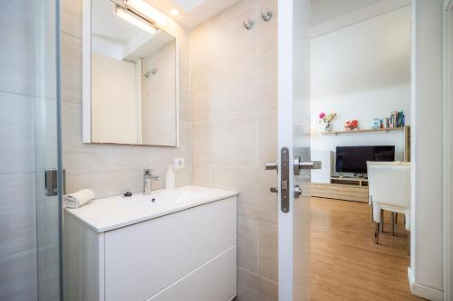 a white bathroom with a sink and a mirror at Ana Playasol in Port d'Alcudia