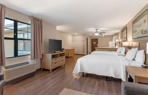 a hotel room with a bed and a television at Extended Stay America Suites - St Petersburg - Clearwater - Executive Dr in Clearwater
