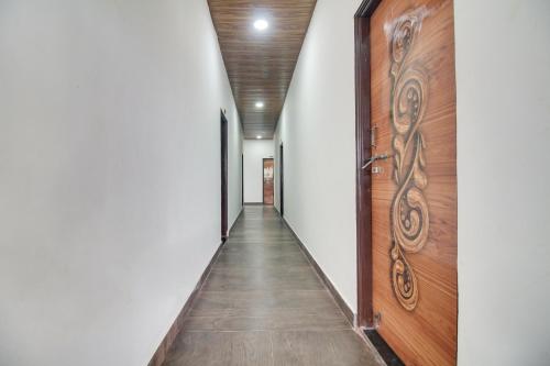 a corridor with a wooden door and a hallway at Hotel O Goyal Inn in Nagpur