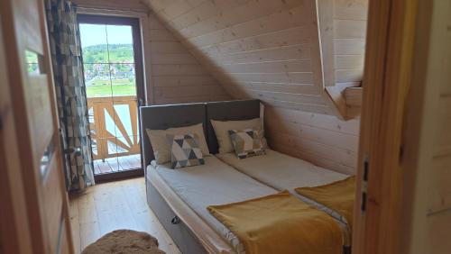 a small bed in a room with a window at Gazdówka in Gródek Nad Dunajcem
