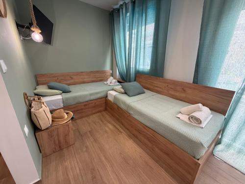 two beds in a room with blue curtains at ΑVLI Sarti Superior Studio no5 in Sarti