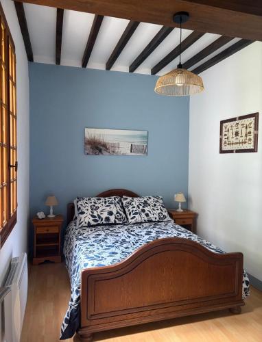 a bedroom with a bed in a blue wall at Au cerisier in Saint-Maulvis