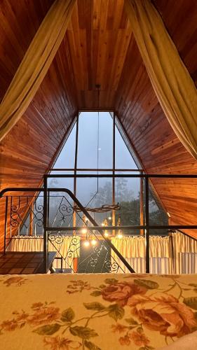 a room with a large window with a bed in it at Chale Pedra do Sol in Caxias do Sul