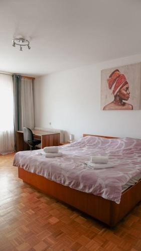 a bedroom with a bed with a painting on the wall at Gacka idila in Otočac