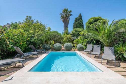 a swimming pool with chairs and a palm tree at Villa Palma - Establiments by PriorityVillas in Palma de Mallorca