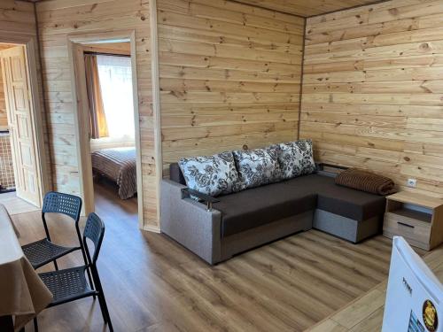 a living room with a couch in a wooden wall at Welcome to Карпати in Skole