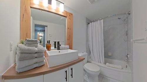 a bathroom with a sink and a toilet and a mirror at Le Summit in Mont-Tremblant
