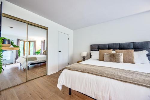 a bedroom with a large bed and a mirror at Le Summit in Mont-Tremblant