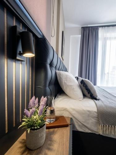 a bedroom with a bed with a black headboard and a table at Olea Luxury Suites in Asprovalta